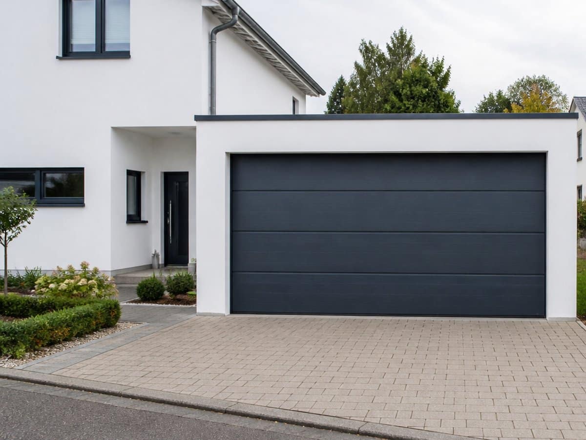Anthrazitfarbenes Hoermann Sektionaltor mit elektrischem Garagentorantrieb an einem modernen Einfamilienhaus